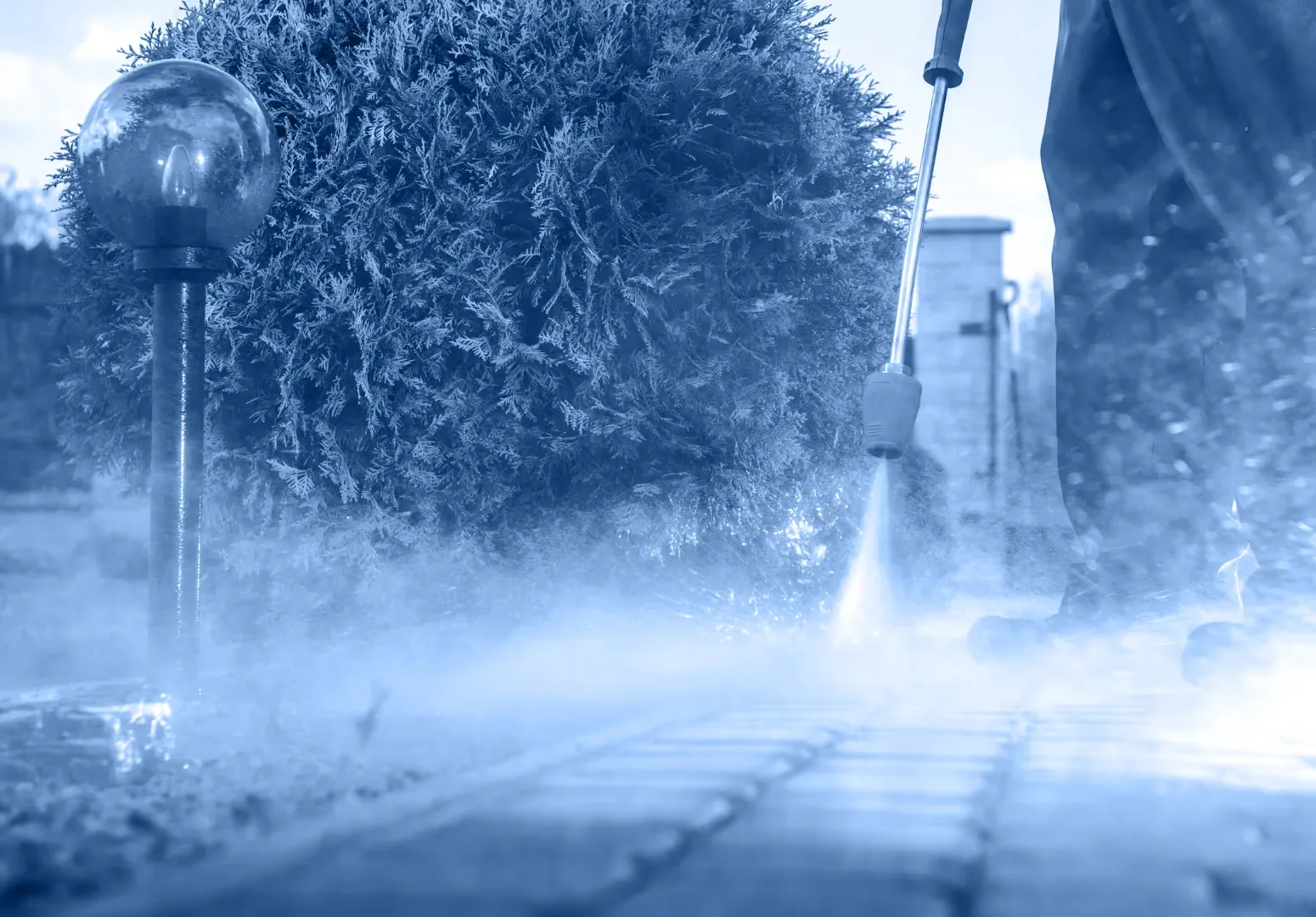 Low angle view of a pressure washer cleaning a paver walkway in Wesley Chapel