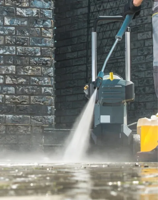 Portable pressure washer unit set up beside a brick commercial wall